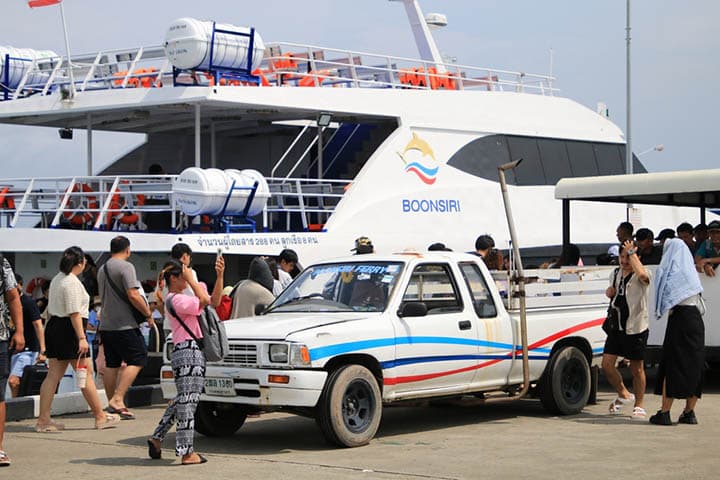 Travelers at Trat pier awaiting Boonsiri Ferry's high-speed catamarans for a journey to Koh Mak, Koh Kood, and Trat, highlighting the excitement of exploring Thailand's islands.